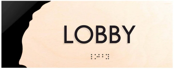 Дерев’яна табличка із чорними літерами та шрифтом Брайля